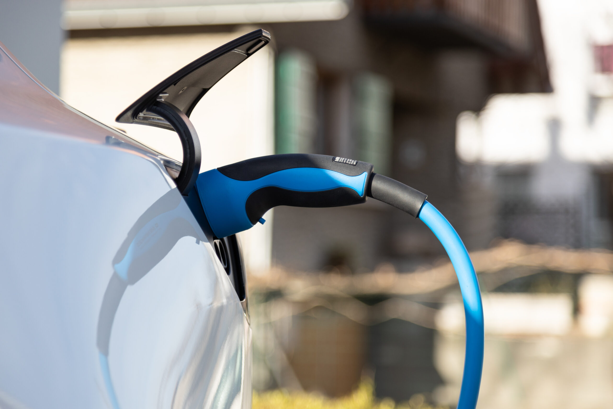 EV electric car pluged charging at a recharge station in the cit